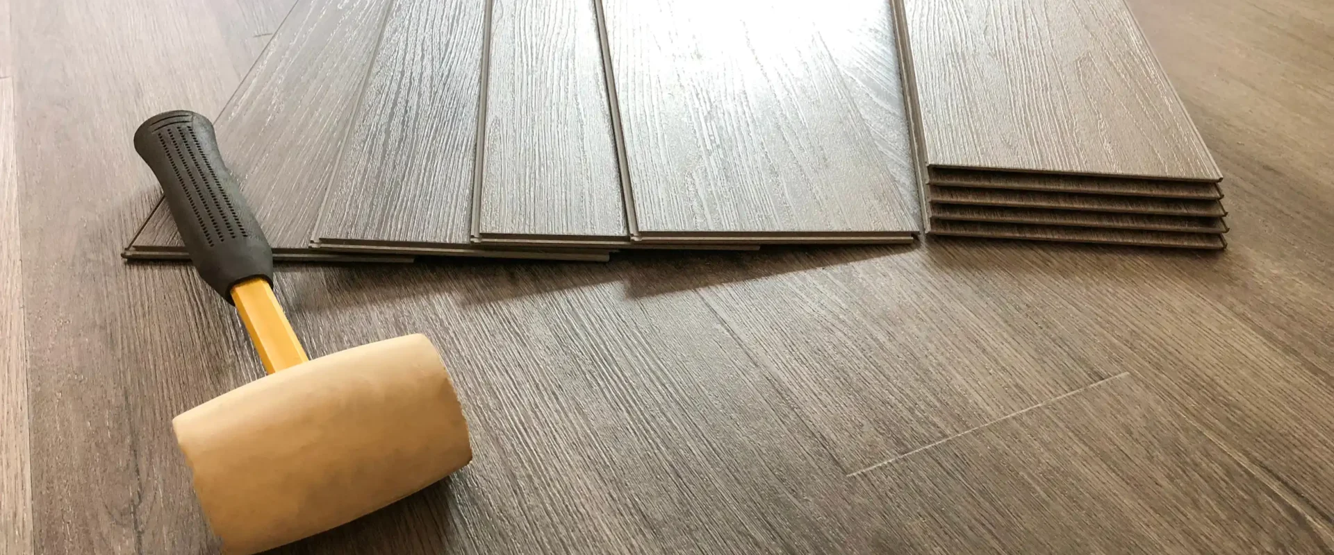 a rubber coated mallet on top of a newly installed vinyl flooring